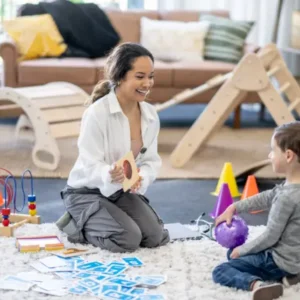 Woman teaching young boy in his living room.