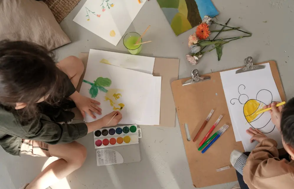 Kids painting art on the floor.